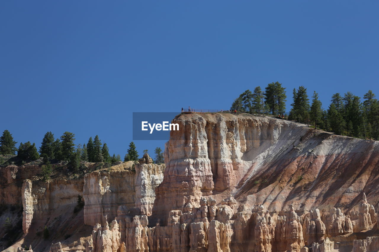 Low angle view of rock formation against clear blue sky