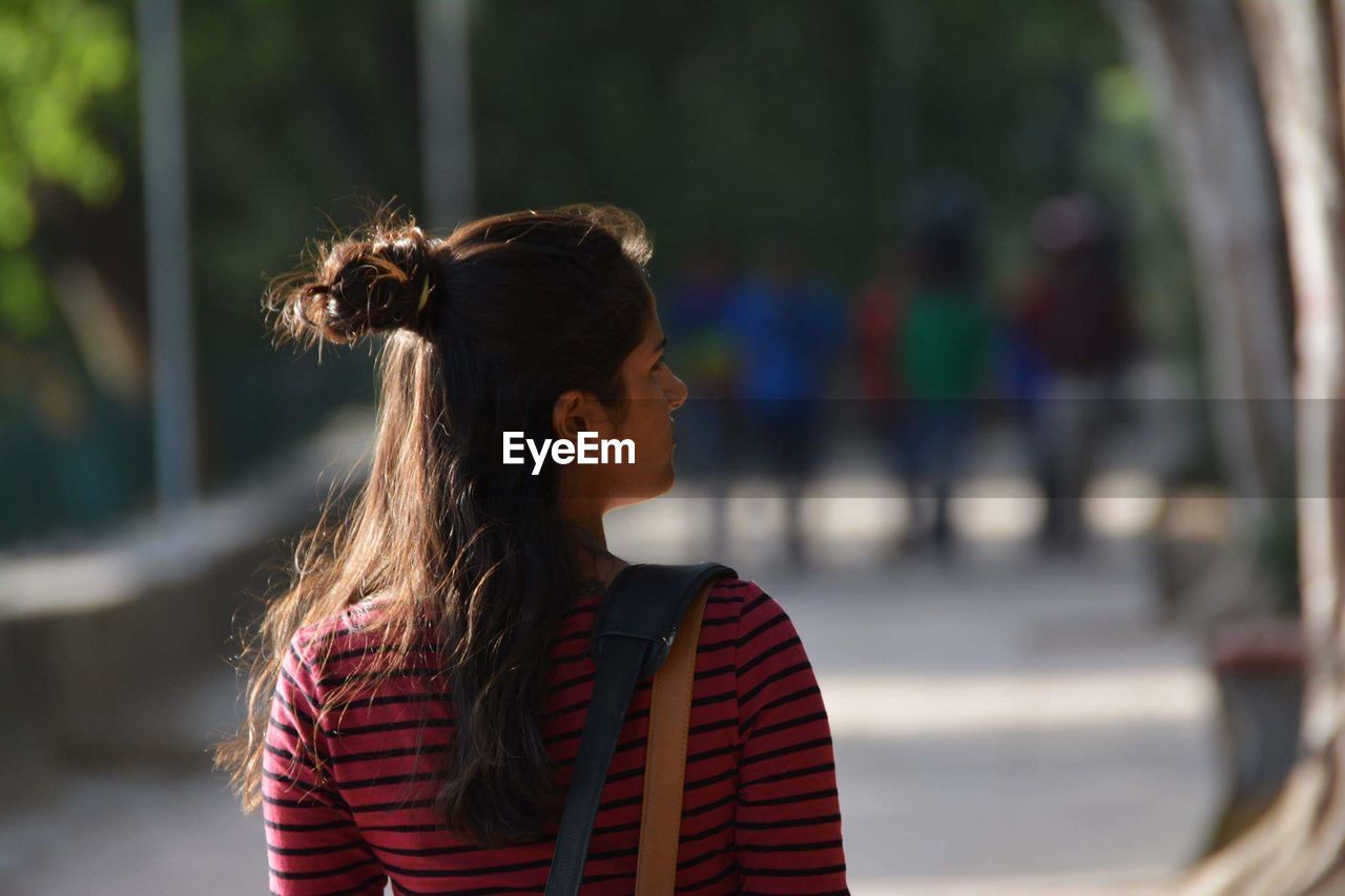 Rear view of young woman on footpath at park