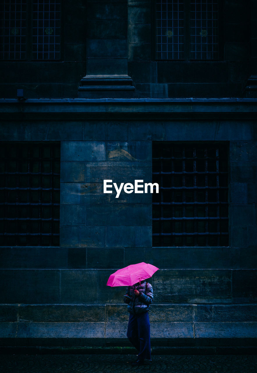 Woman standing on wet umbrella during rainy season