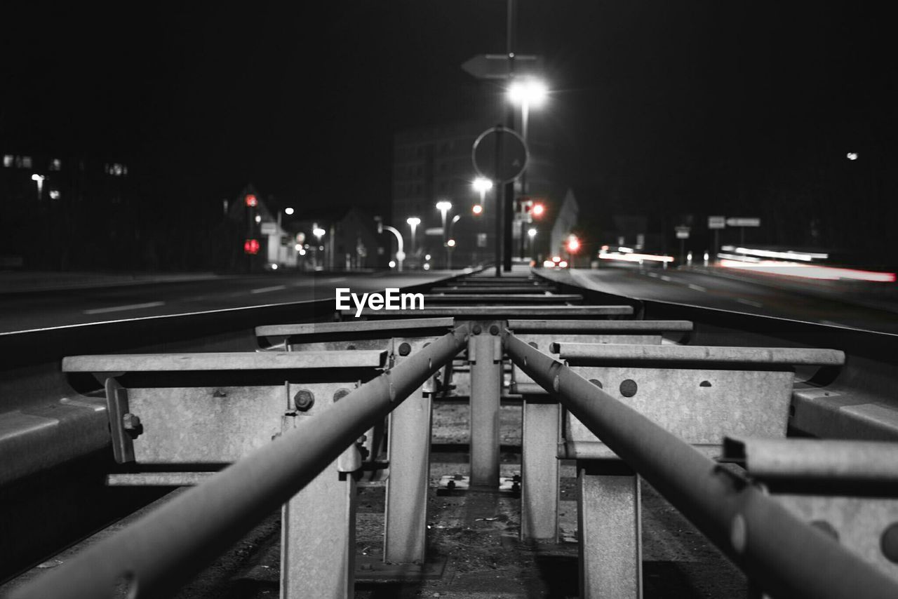 Illuminated railroad tracks in city at night