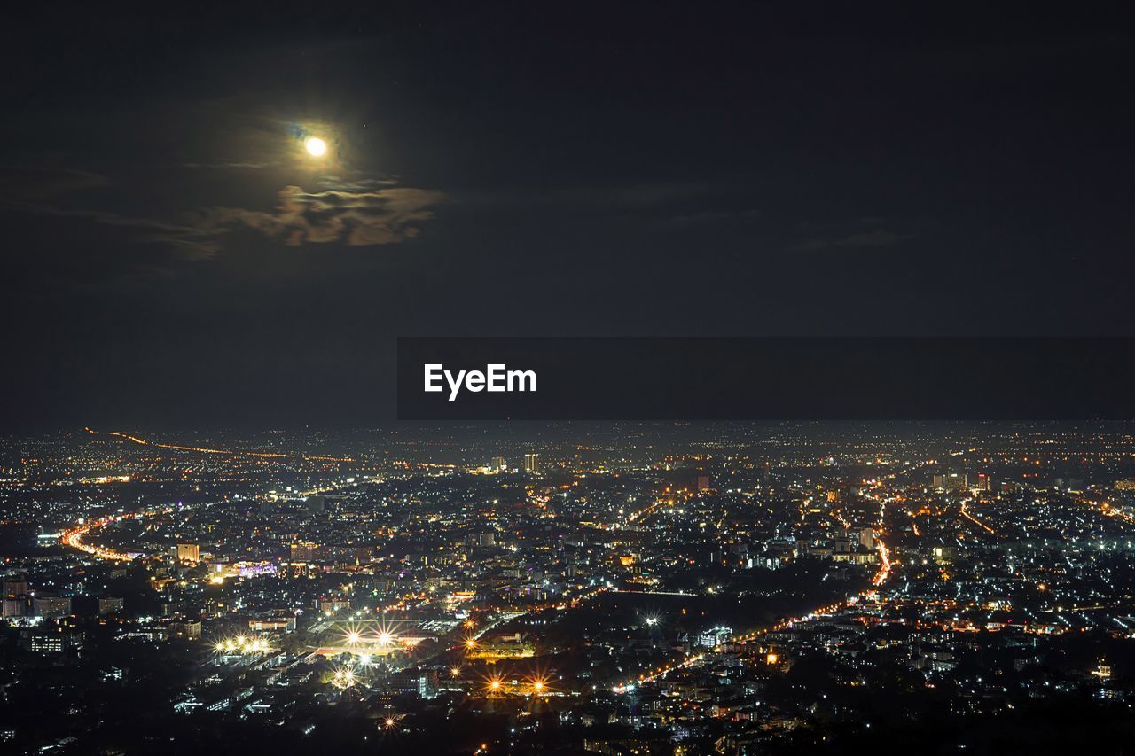 Aerial view of illuminated city against sky at night