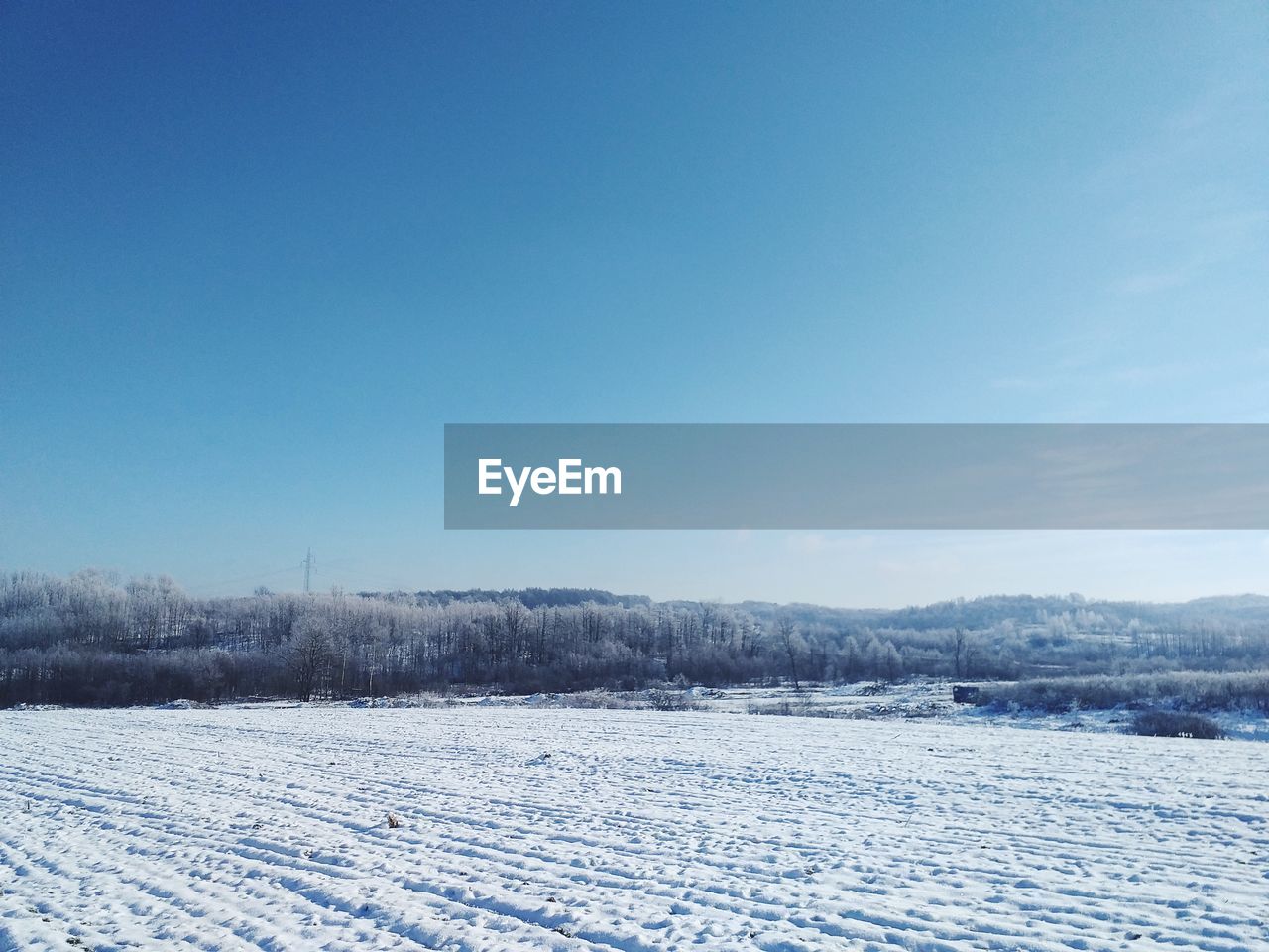 SCENIC VIEW OF SNOW COVERED LAND AGAINST BLUE SKY