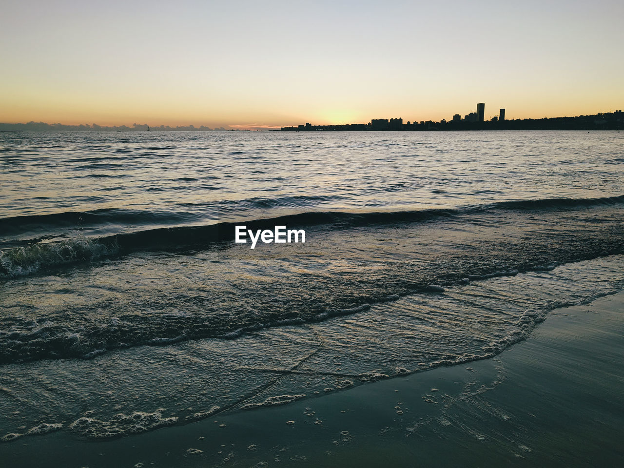 SCENIC VIEW OF BEACH AT SUNSET