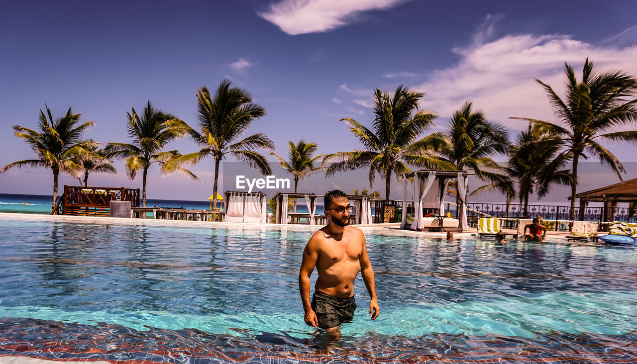 YOUNG MAN IN SWIMMING POOL