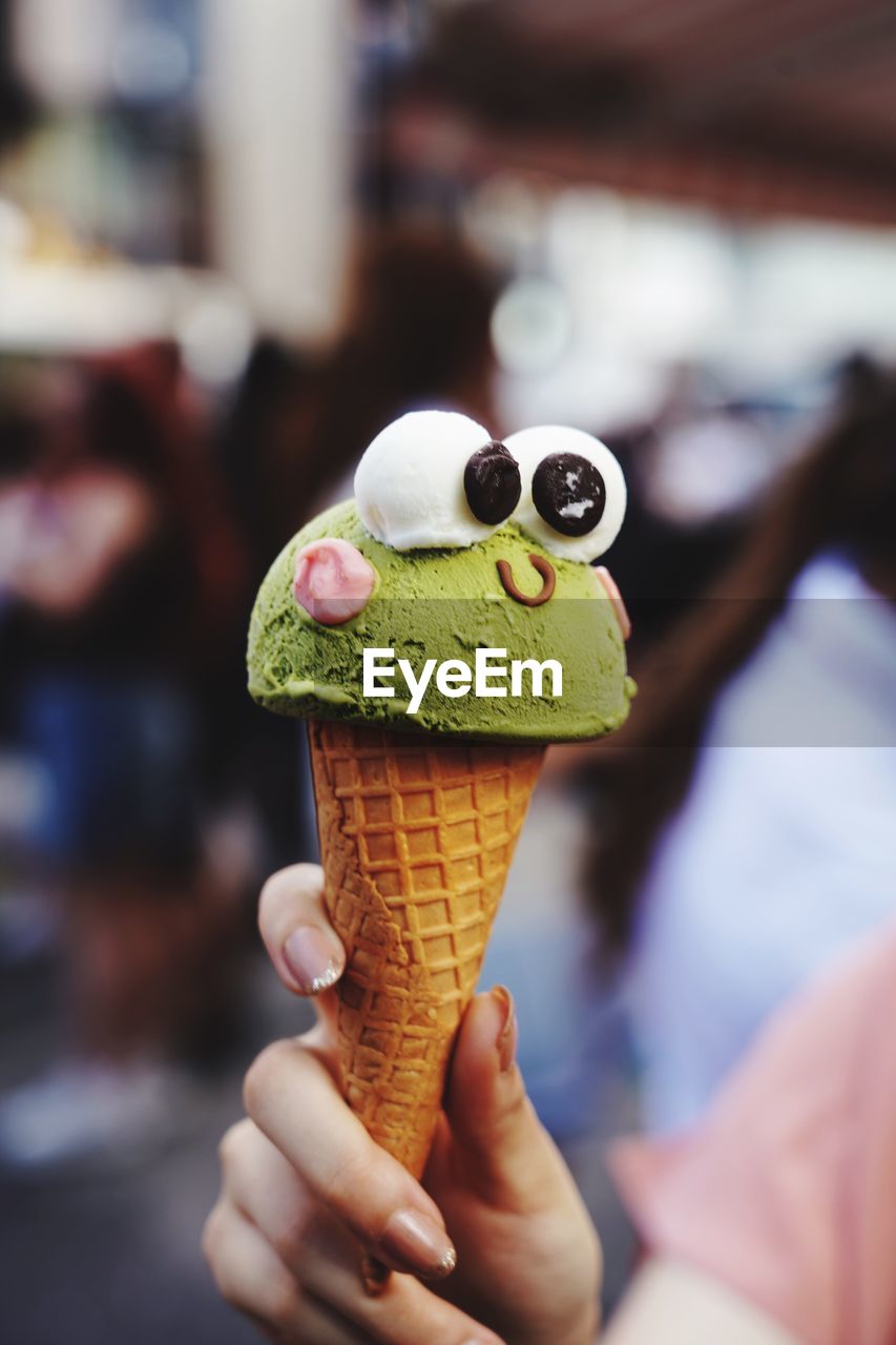 Person holding ice cream cone with face