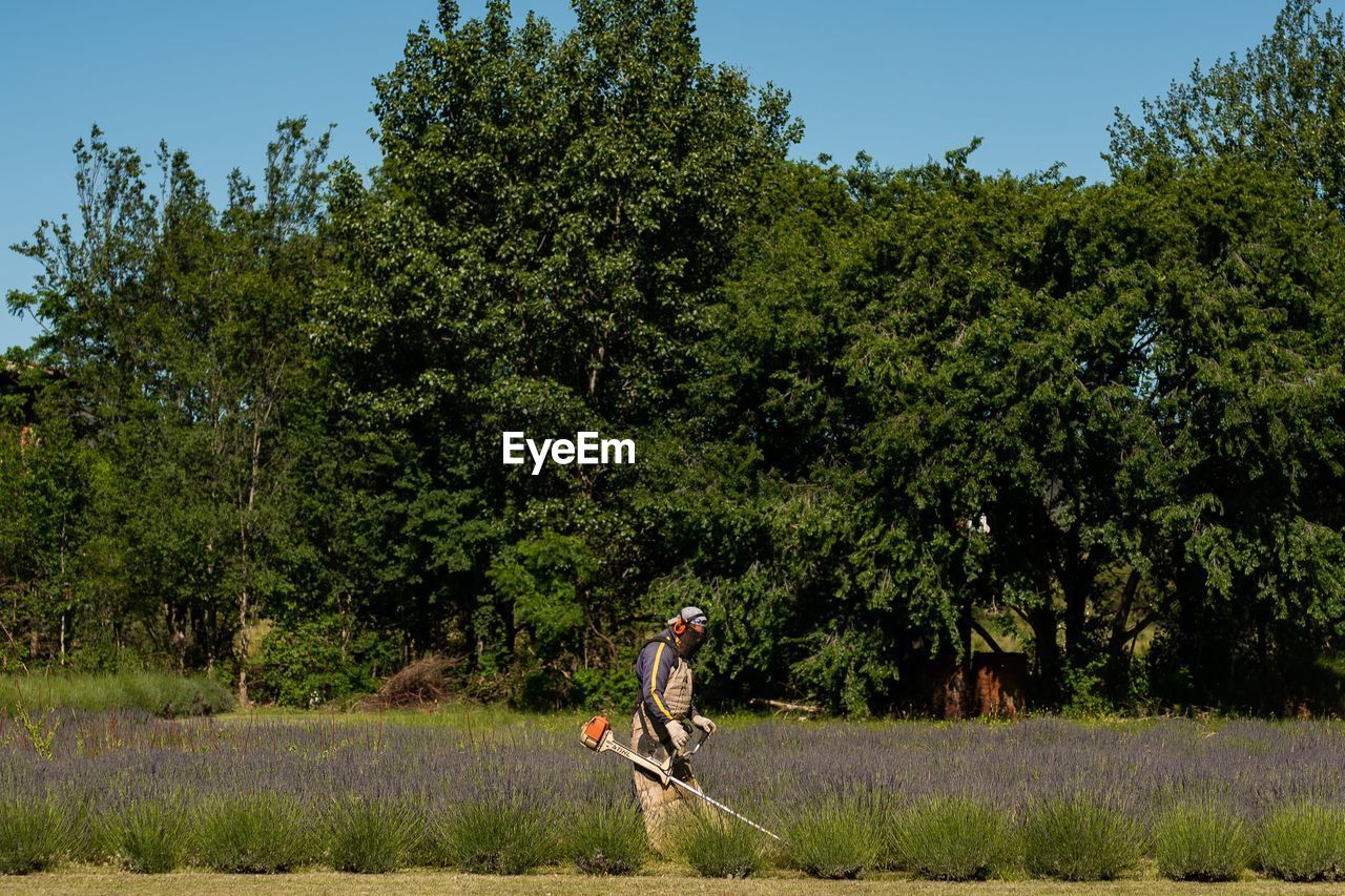 Rear view of woman walking on field