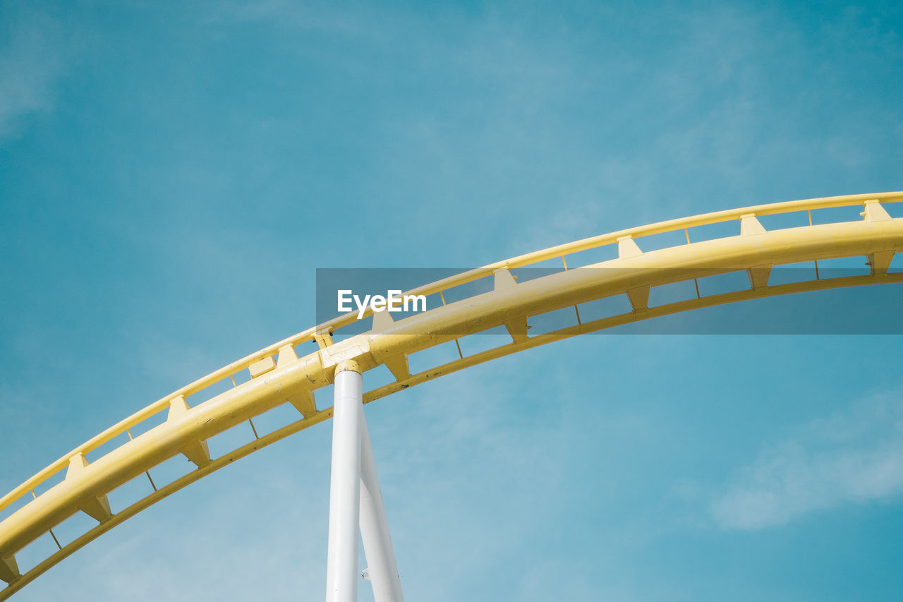 Cropped image of amusement park ride against blue sky