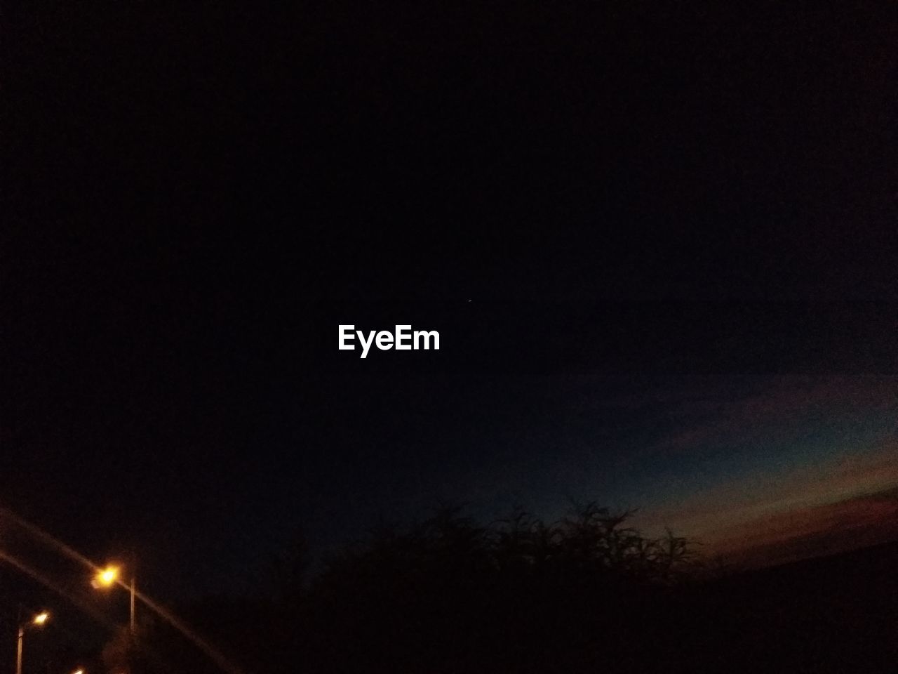 LOW ANGLE VIEW OF ILLUMINATED STREET LIGHTS AGAINST SKY