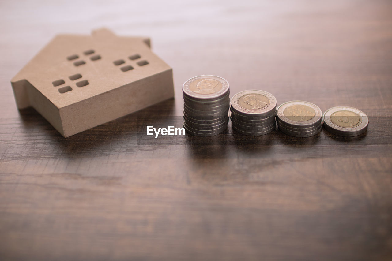 HIGH ANGLE VIEW OF COINS IN CONTAINER ON TABLE