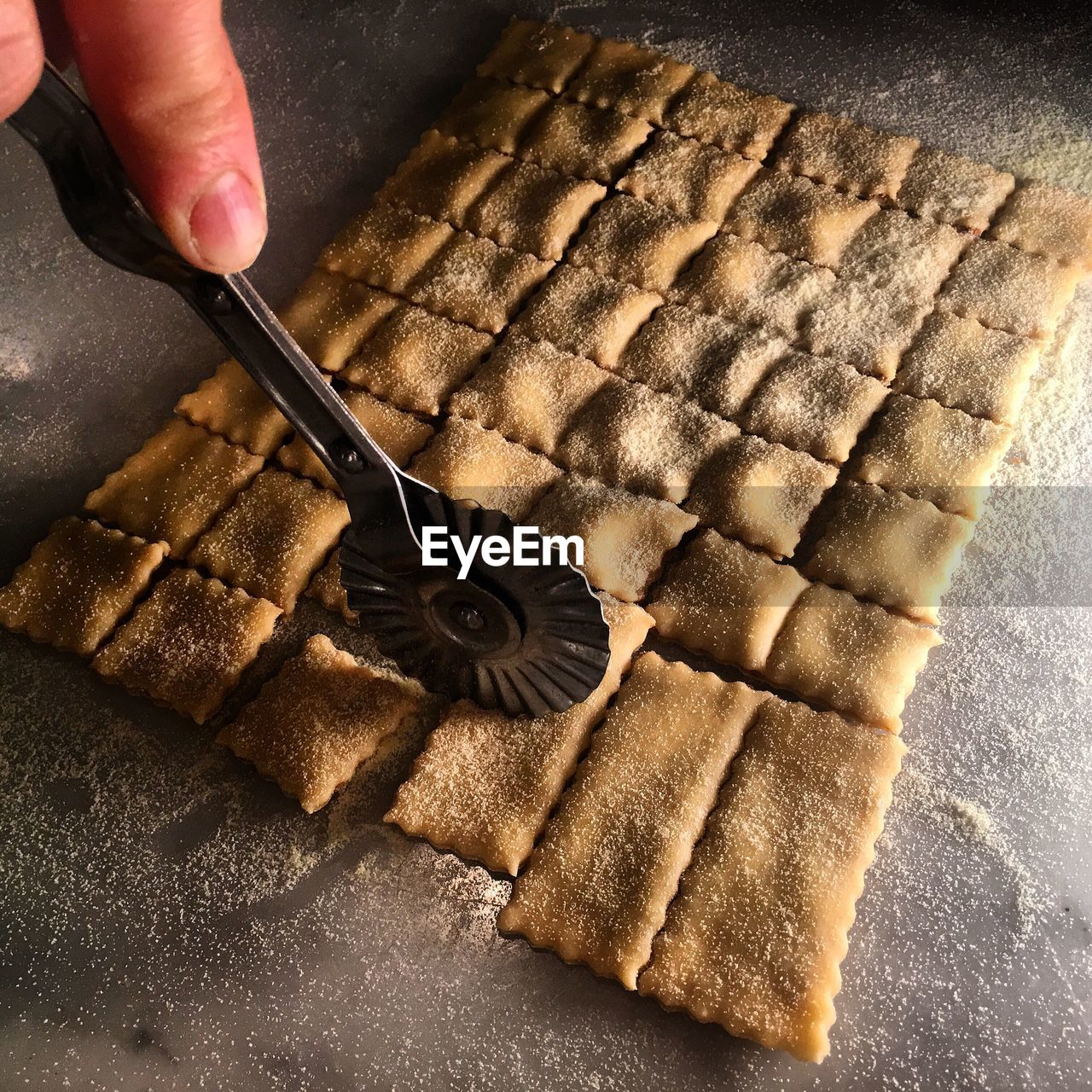 Cropped hand cutting pasta