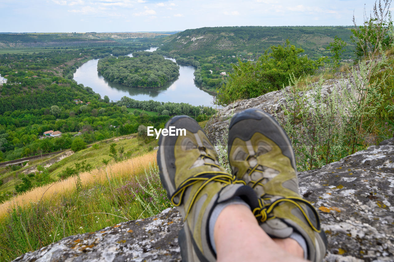 LOW SECTION OF MAN WEARING SHOES ON LAND