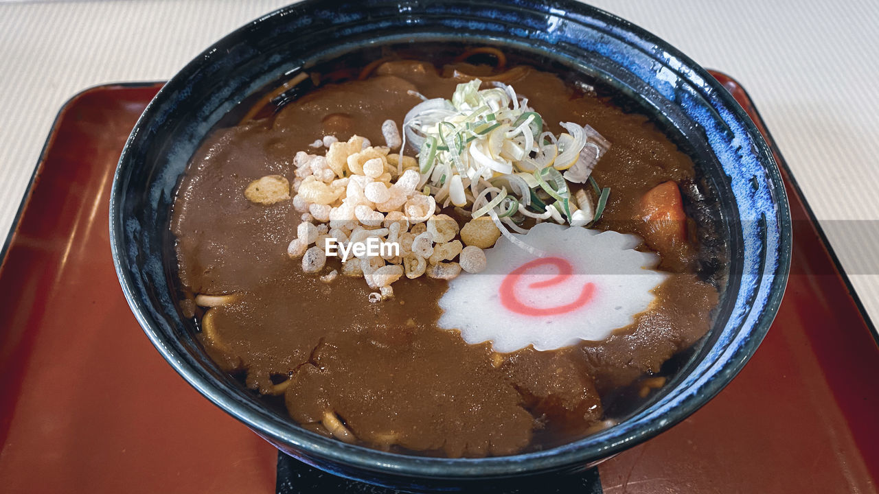 Eating curry soba noodles in restaurant - japanese food and culture