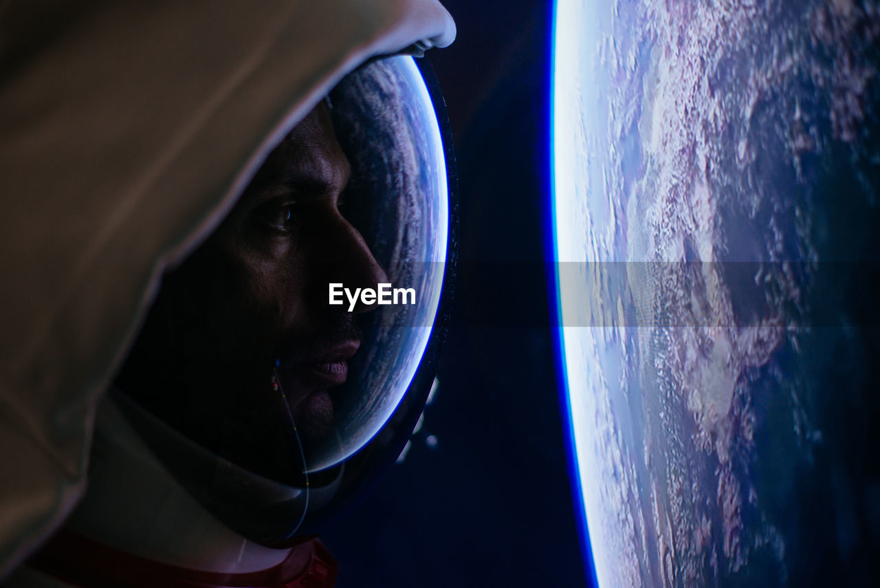 Close-up of astronaut looking at earth from outer space