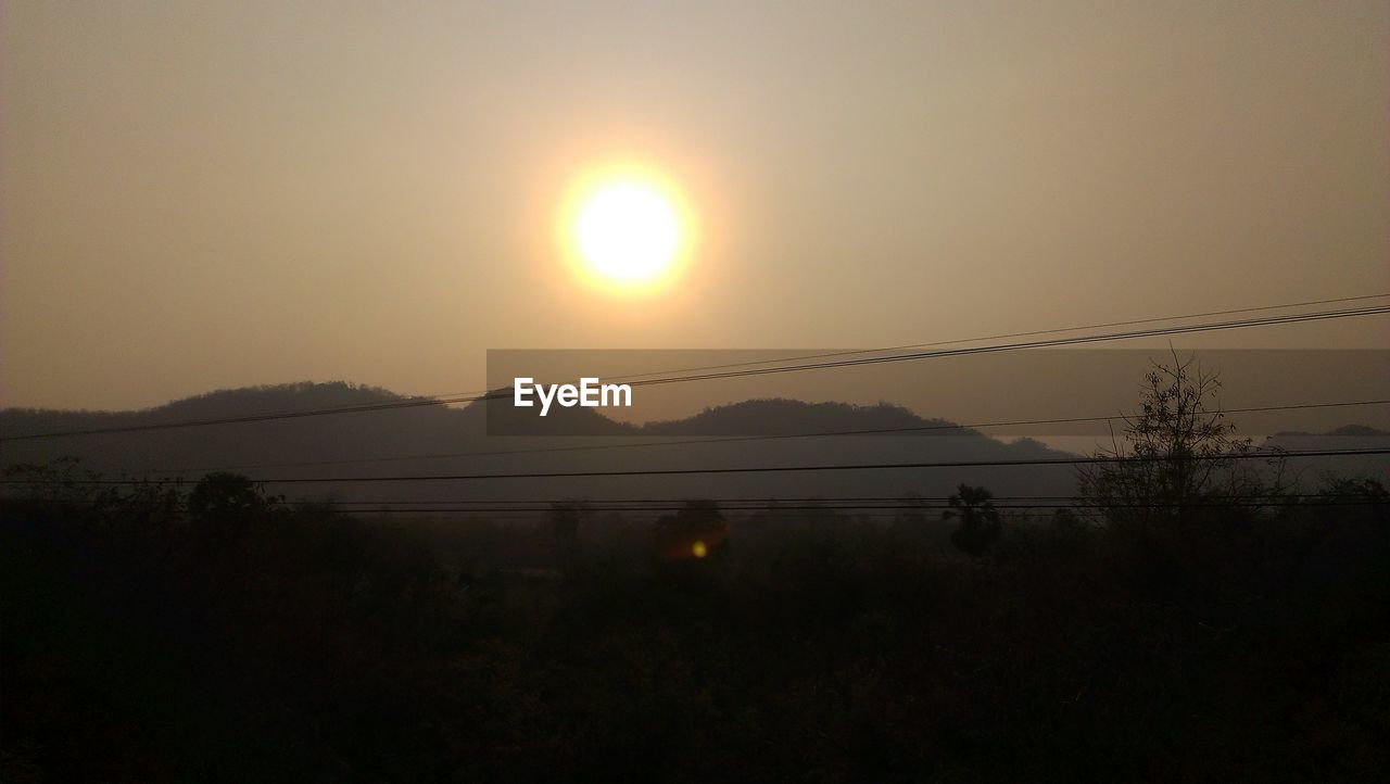 SCENIC VIEW OF SILHOUETTE MOUNTAIN AGAINST SKY AT SUNSET