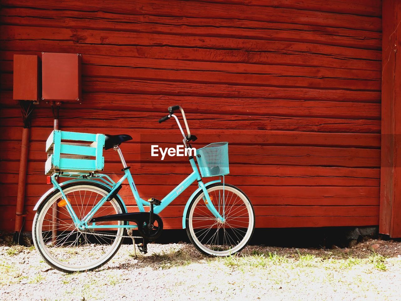 Bicycle parked by wooden wall