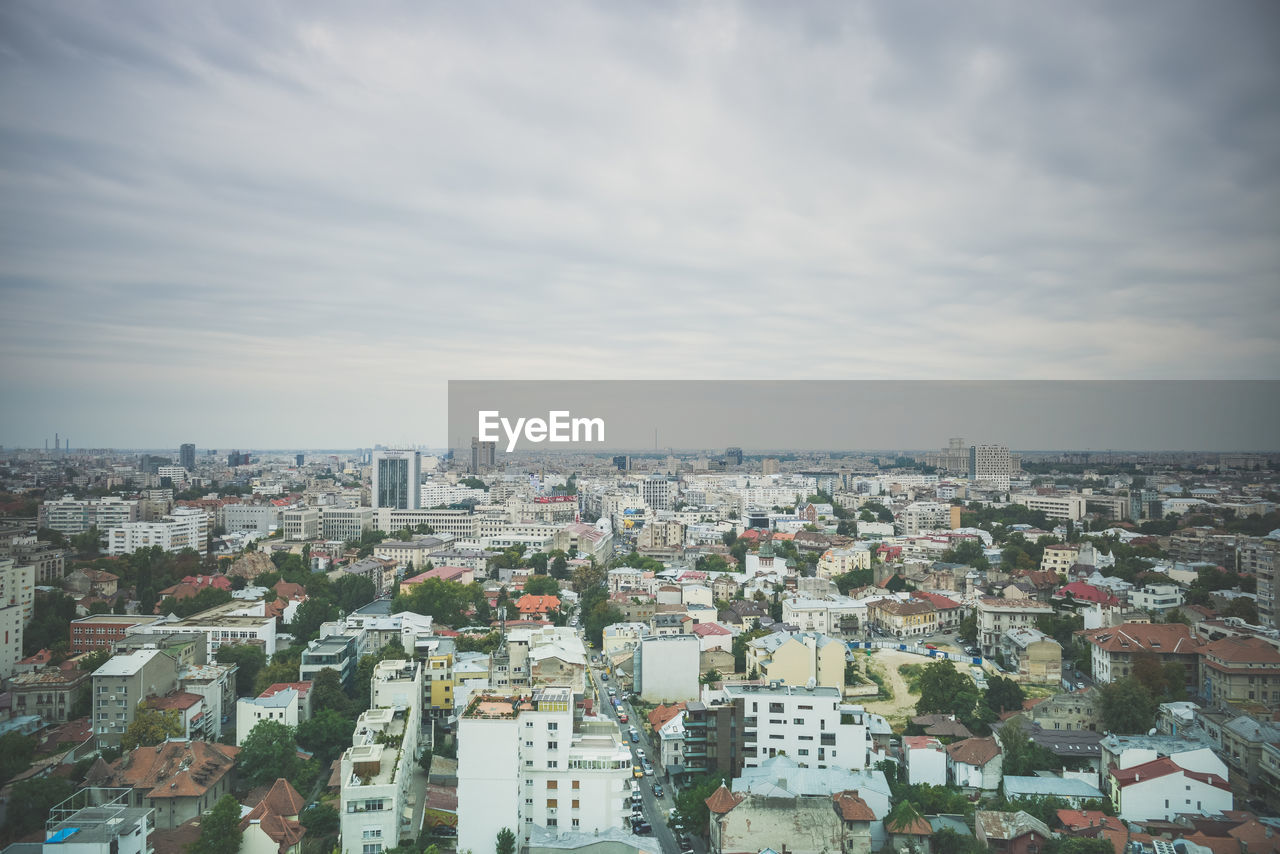 HIGH ANGLE VIEW OF MODERN BUILDINGS IN CITY AGAINST SKY