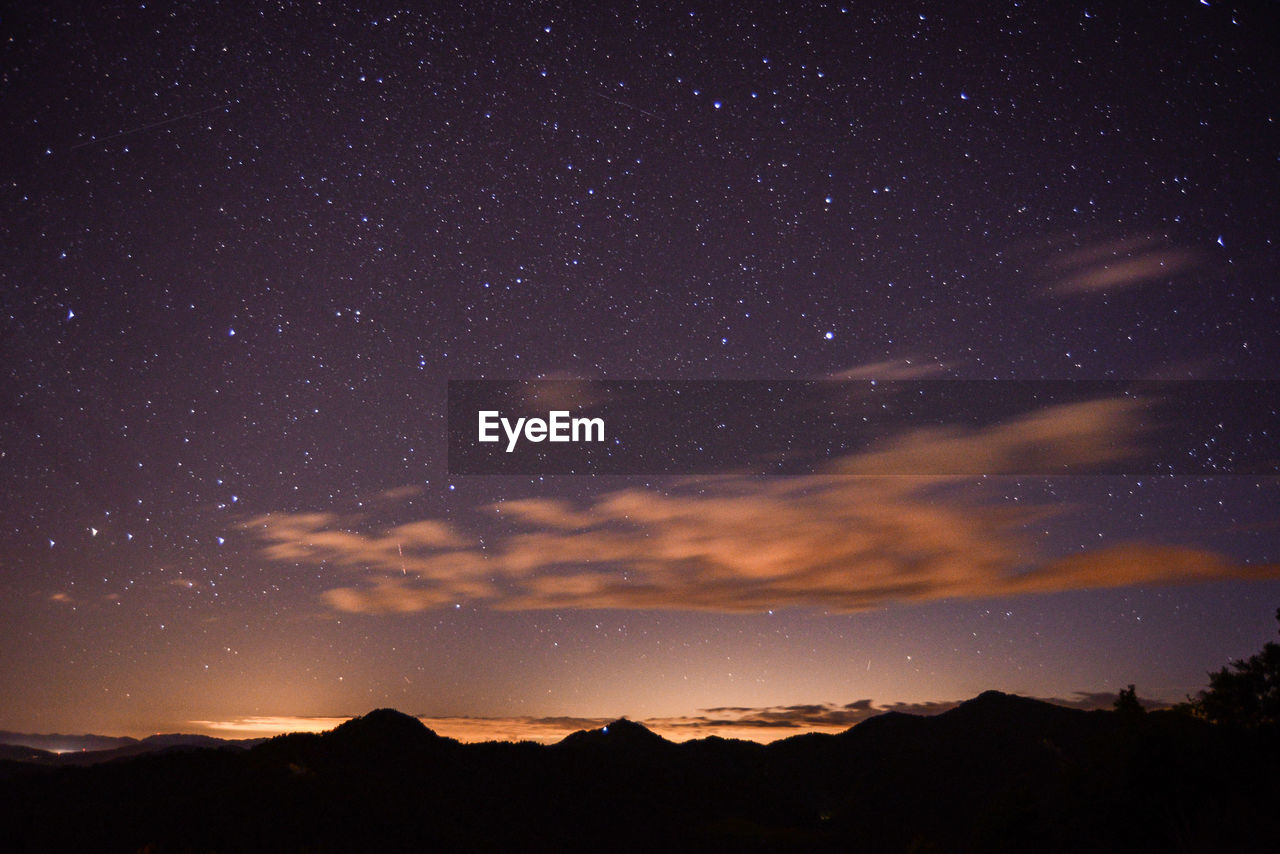 SCENIC VIEW OF SILHOUETTE MOUNTAINS AGAINST SKY AT NIGHT