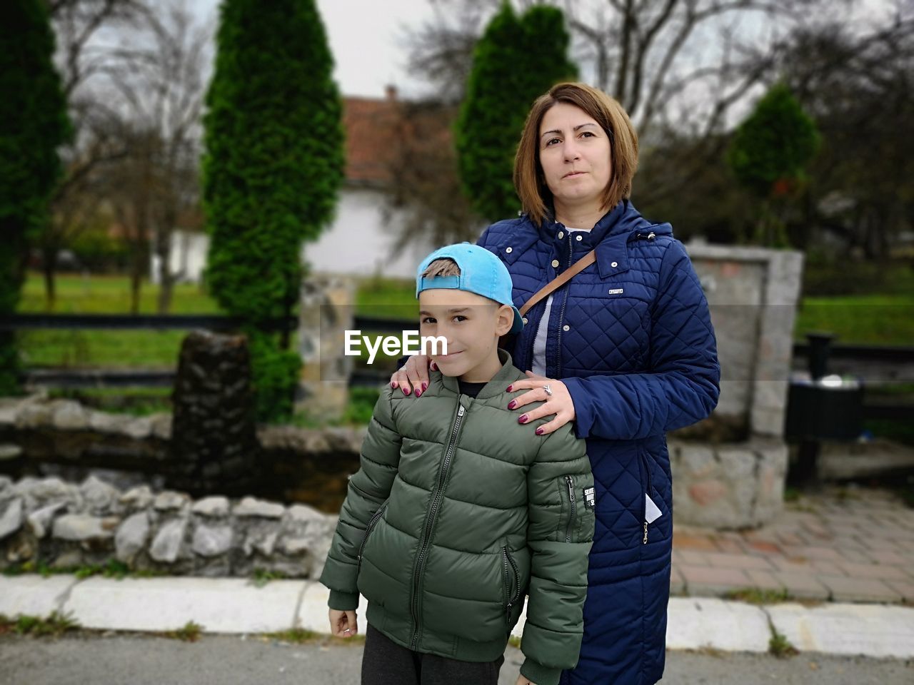 Portrait of mother and son standing at park 