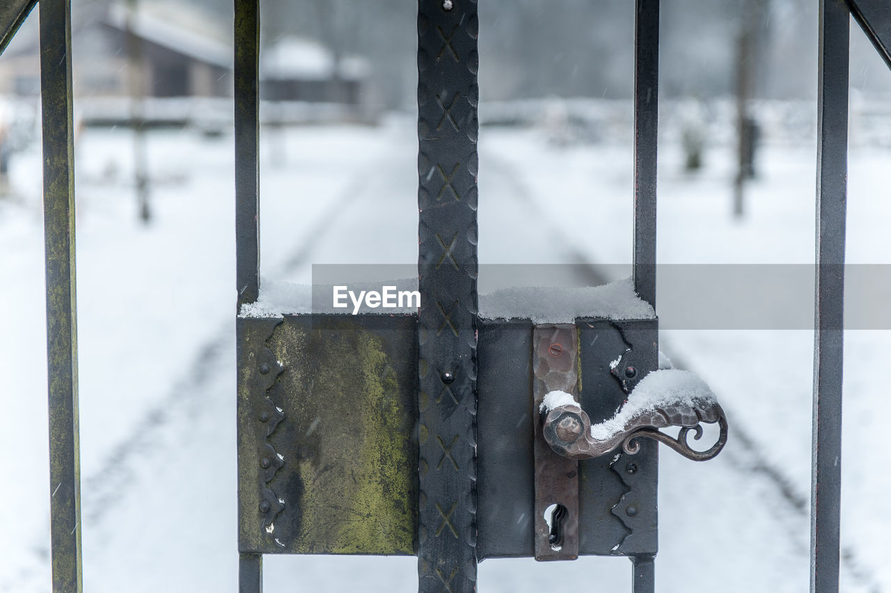 Close-up of snow on metal door handle on cemetery