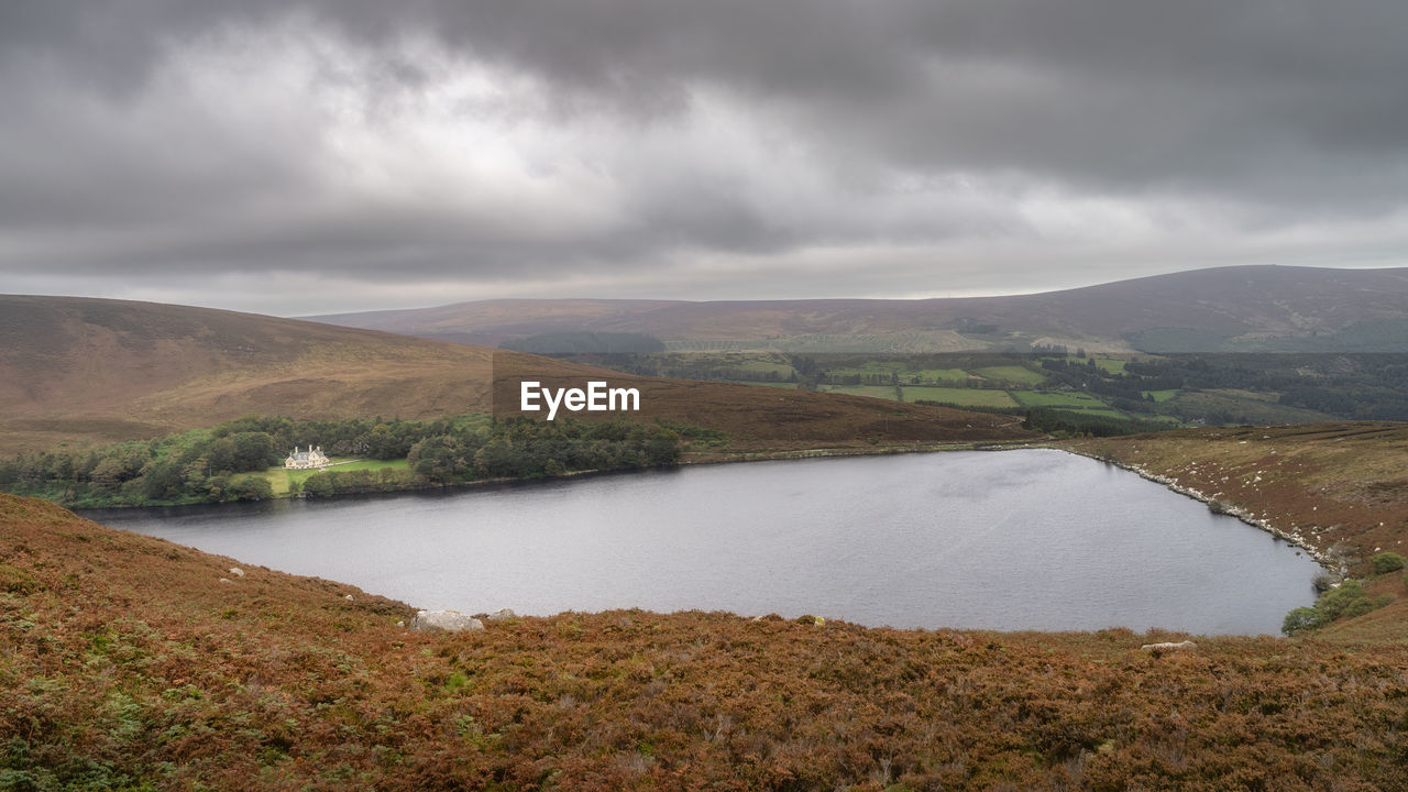 Mansion hiding in small forest at the edge of lake lough bray in wicklow mountains