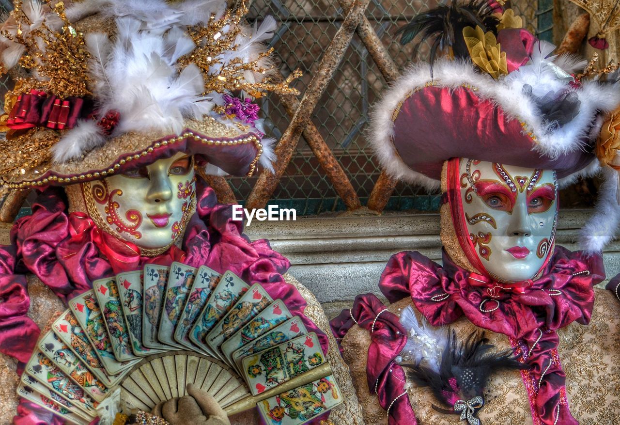 People wearing costumes sitting against wall