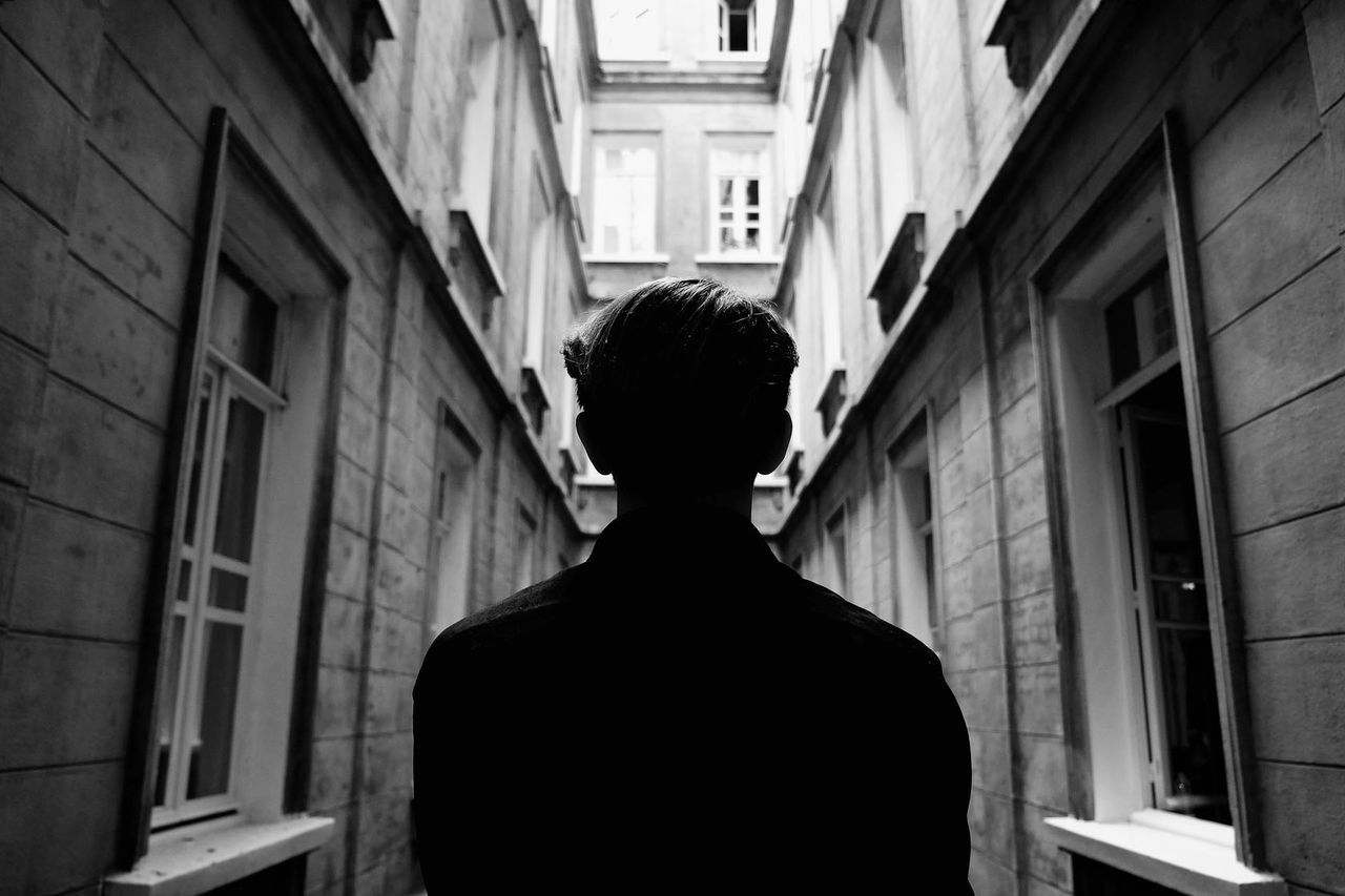 Rear view of man standing in alley