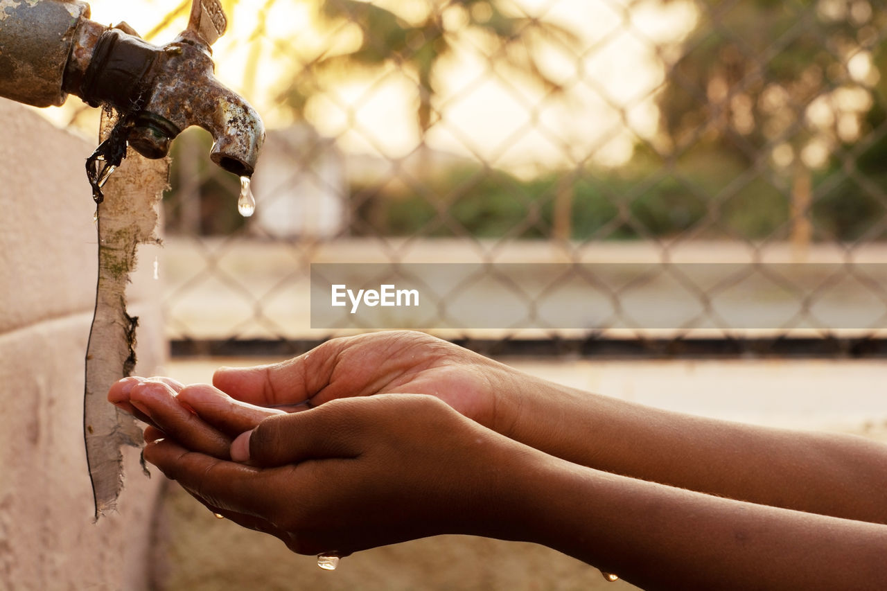 Cropped image of person washing hands