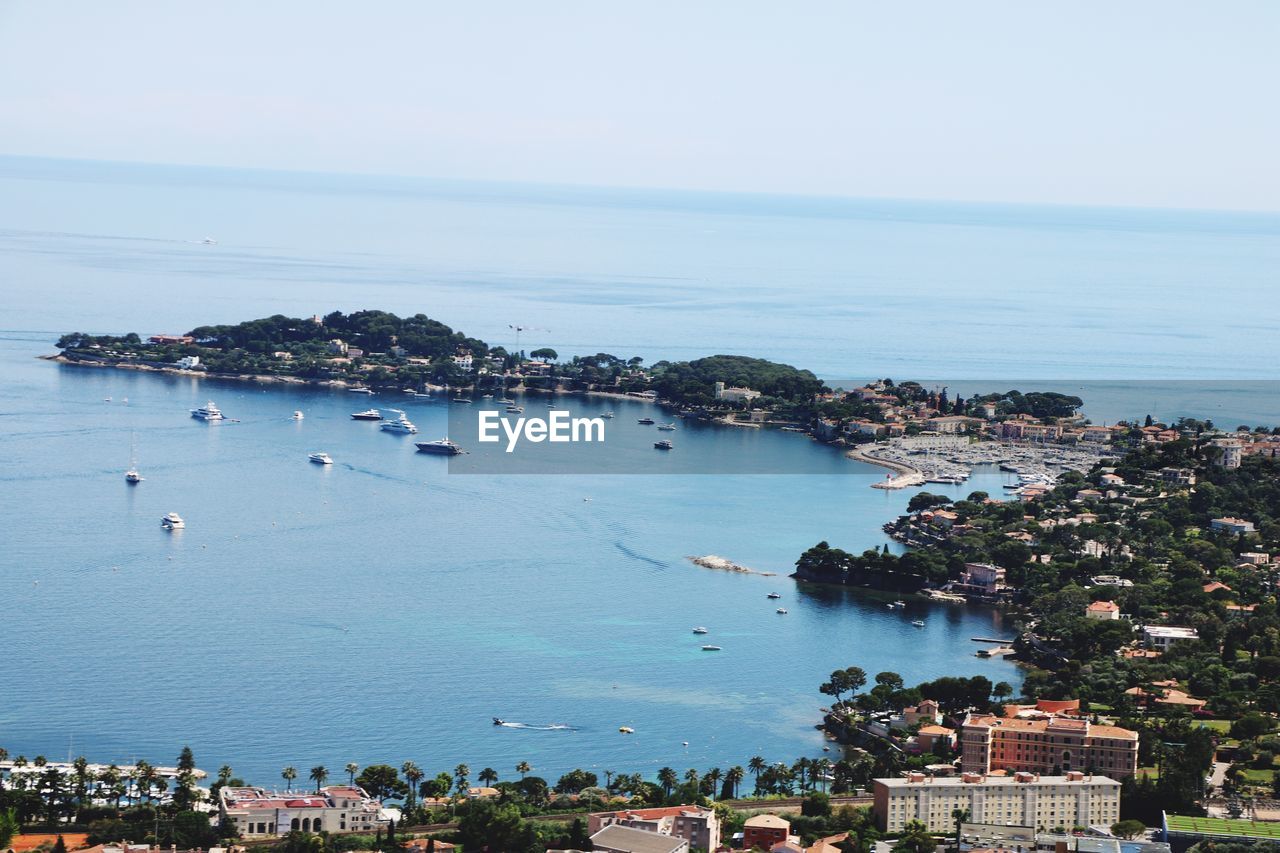 High angle view of city by sea against sky