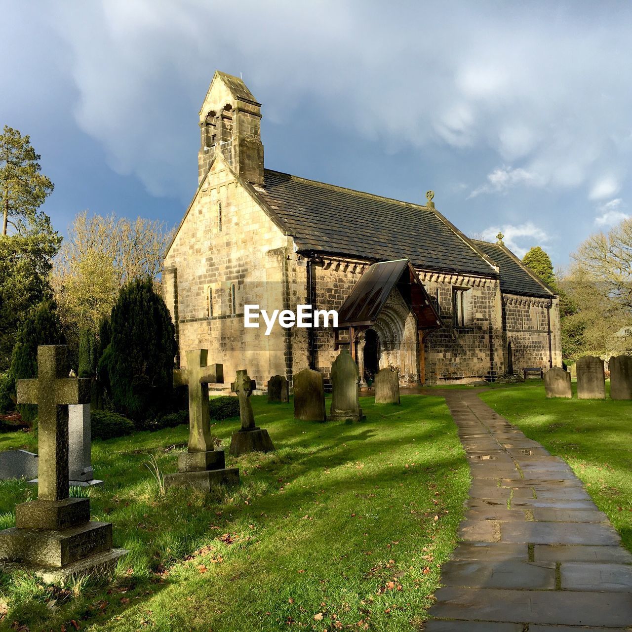 Graveyard outside st john the baptist church against cloudy sky