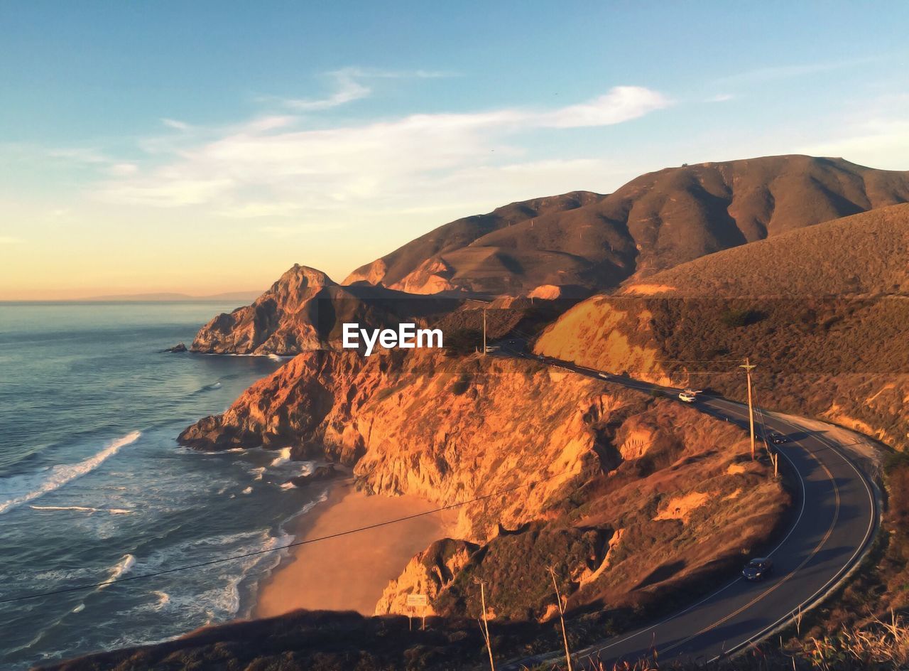 High angle view of sea by mountains against sky