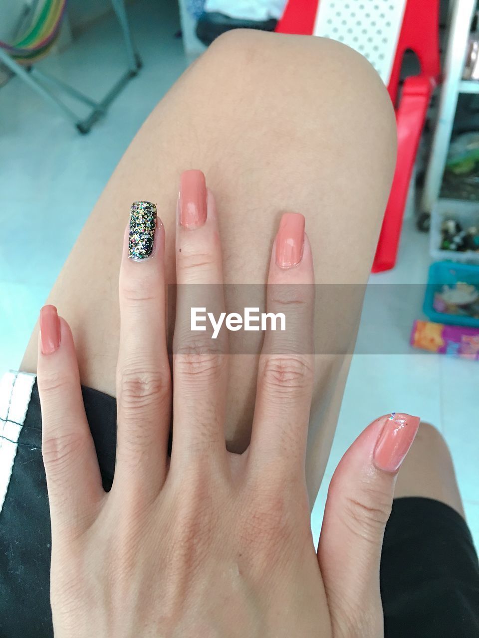 Midsection of woman showing nails at home