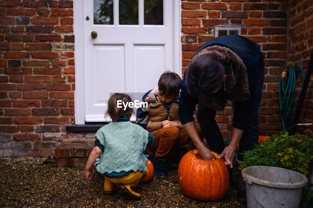 Mother and her children are preparing pumpkins for halloween 
