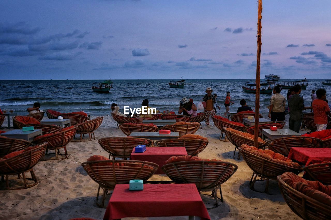 Tourists at outdoor restaurant overlooking beach