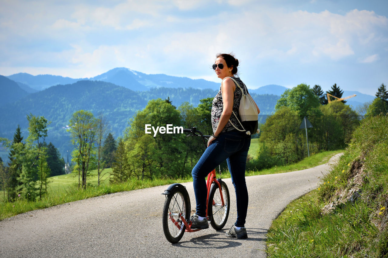 Young woman riding bicycle on road