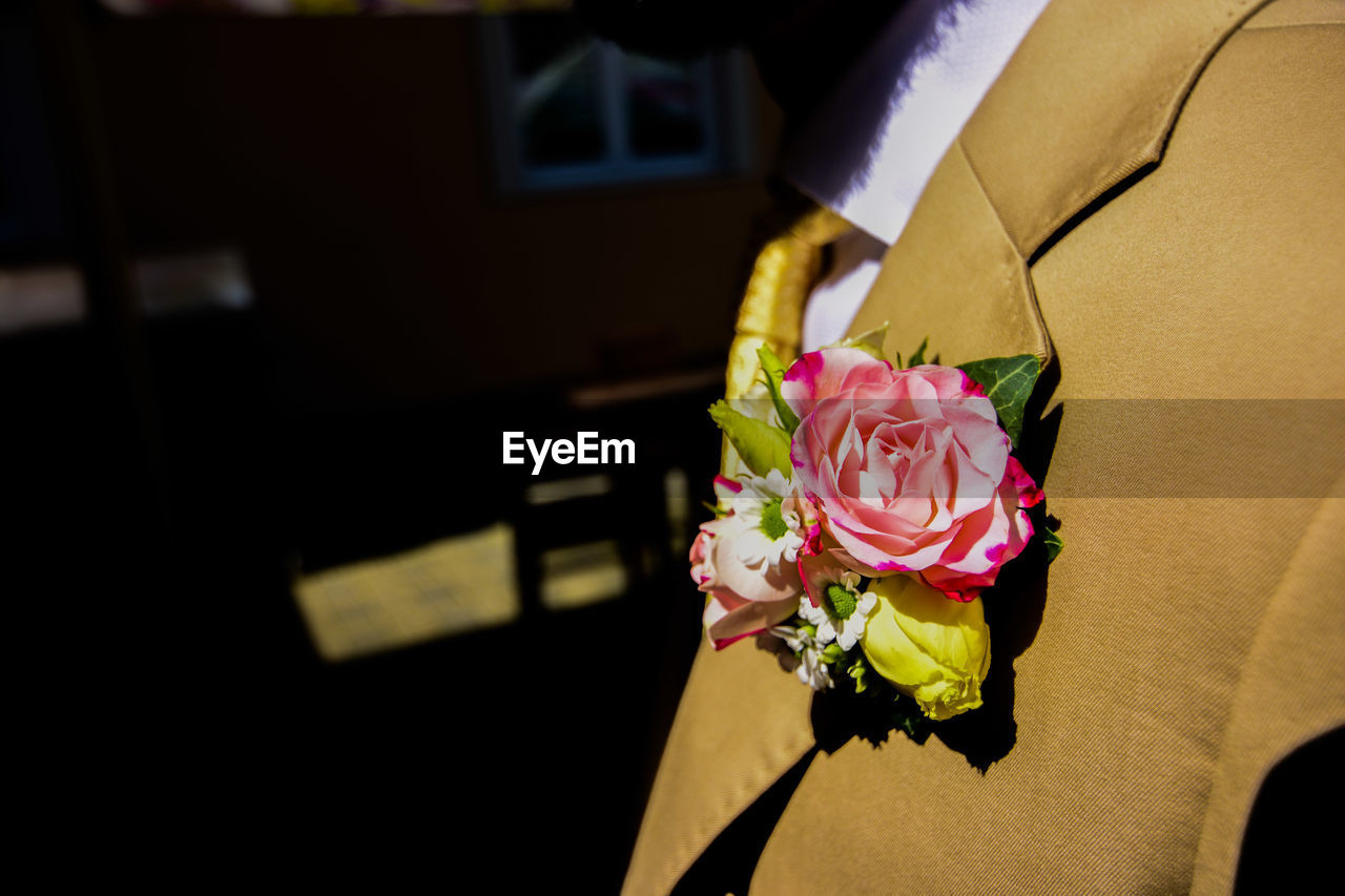 Close-up of bridegroom with flowers on his suit