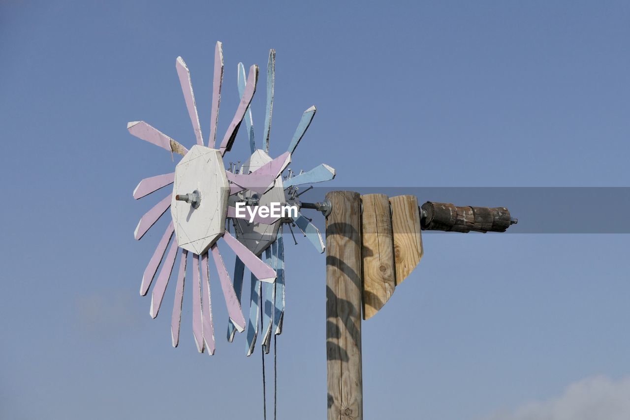 Low angle view of traditional windmill against clear blue sky