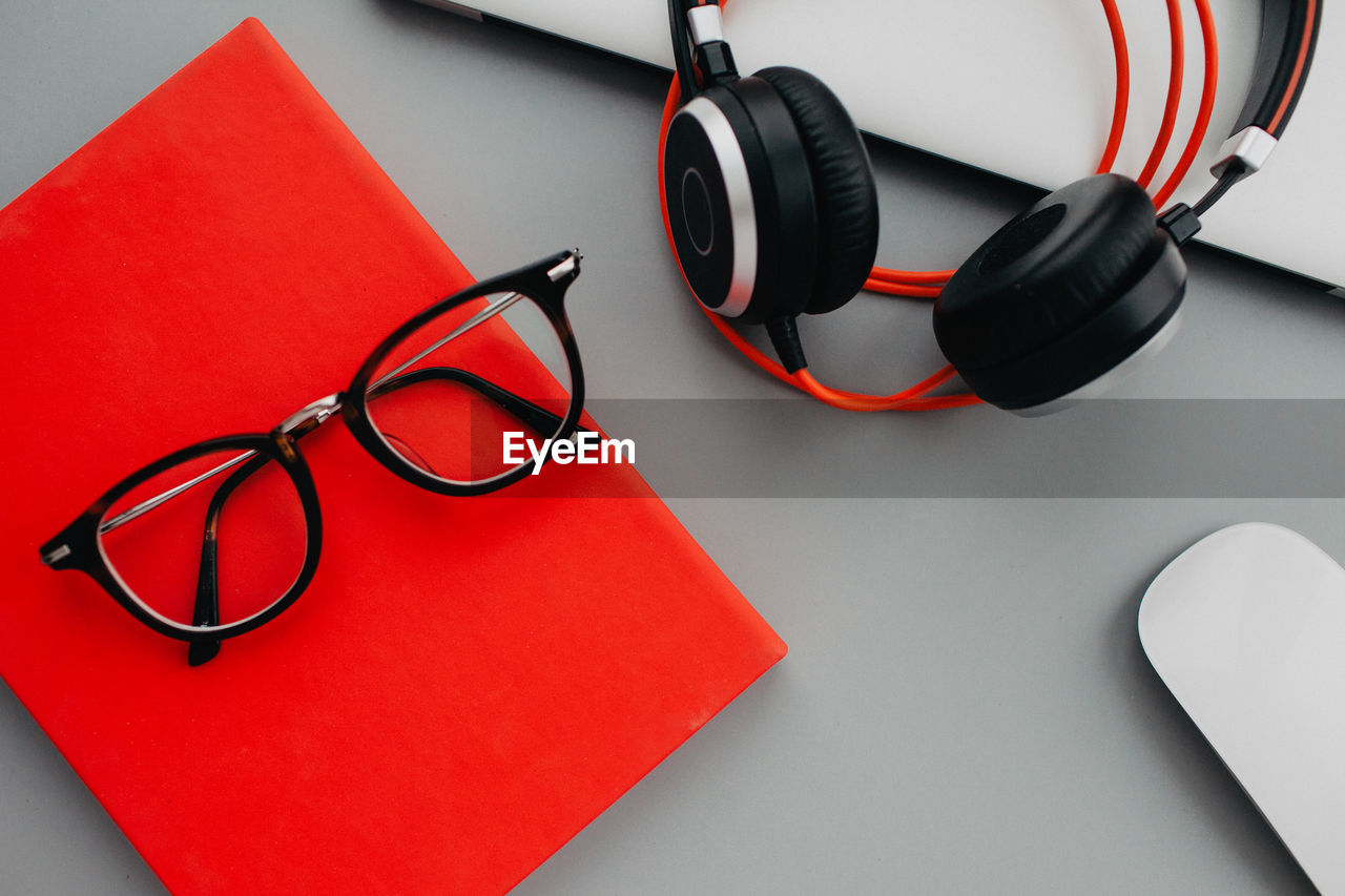 eyeglasses, headphones, glasses, red, indoors, stethoscope, technology, no people, medical instrument, studio shot, still life, gadget, medical equipment, high angle view, listening, medical supplies, close-up, communication, font, table, group of objects, healthcare and medicine