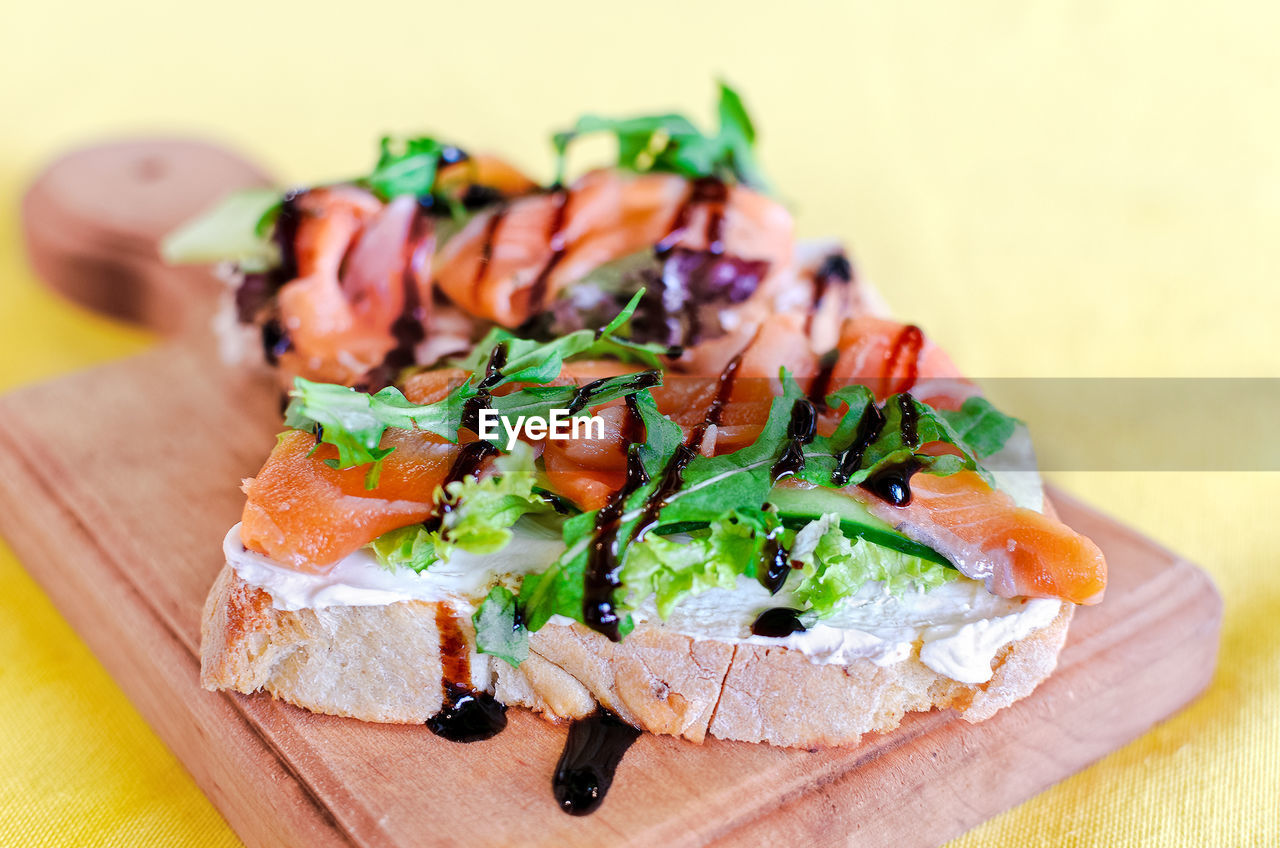 Sandwich with red fish, cheese and arugula on a board. selective soft focus. copy space