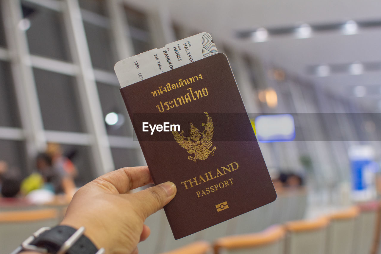 Cropped hand holding passport at airport