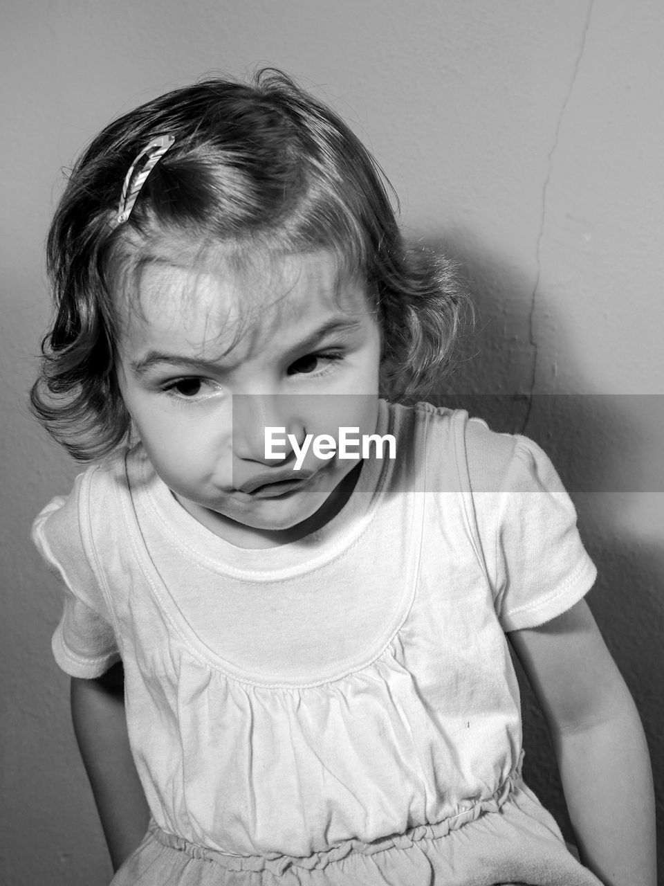 Close-up of girl puckering while standing against wall