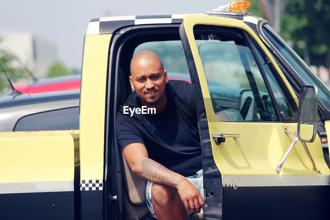 Portrait of smiling man sitting in pick-up truck