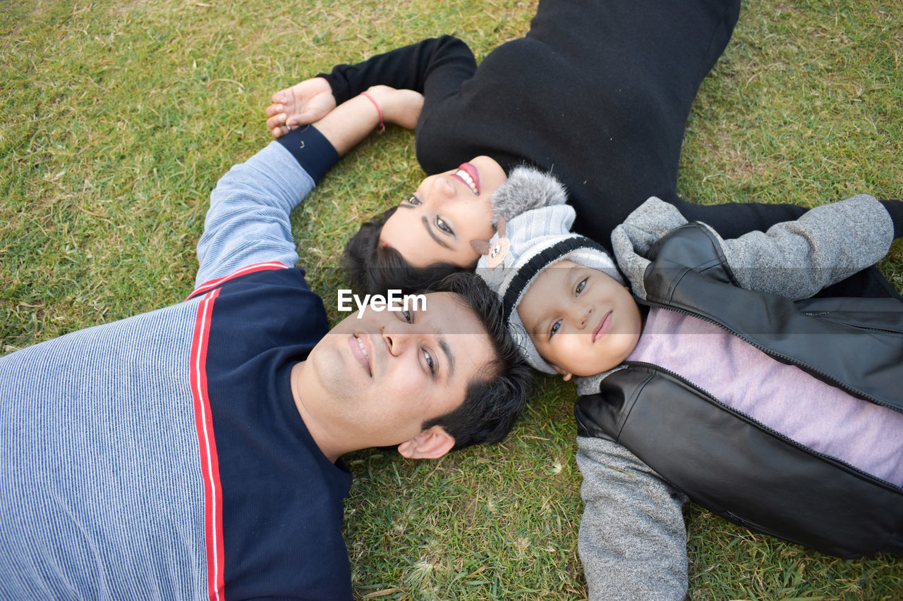 Portrait of happy family lying on grass