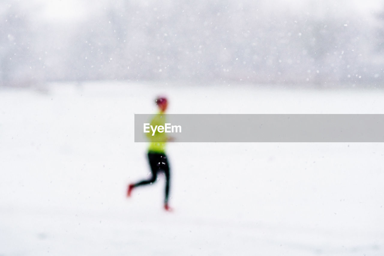 Defocused image of person running on snowfield