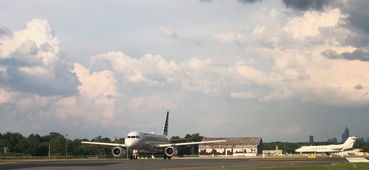 AIRPLANE AT AIRPORT AGAINST SKY