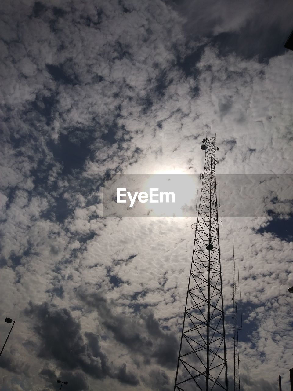 LOW ANGLE VIEW OF COMMUNICATIONS TOWER AGAINST CLOUDY SKY