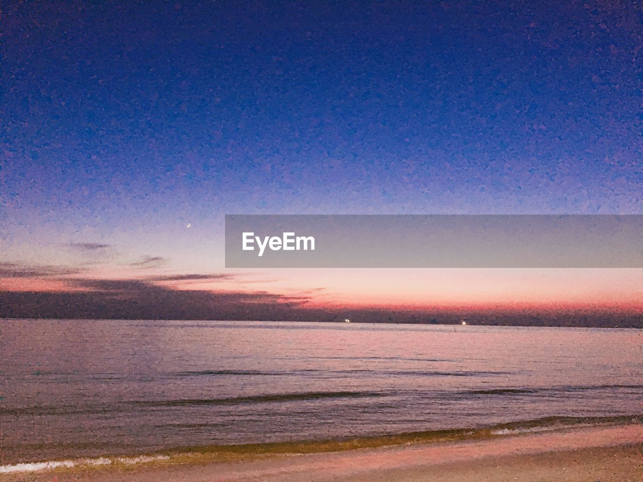 SCENIC VIEW OF BEACH AGAINST SKY DURING SUNSET