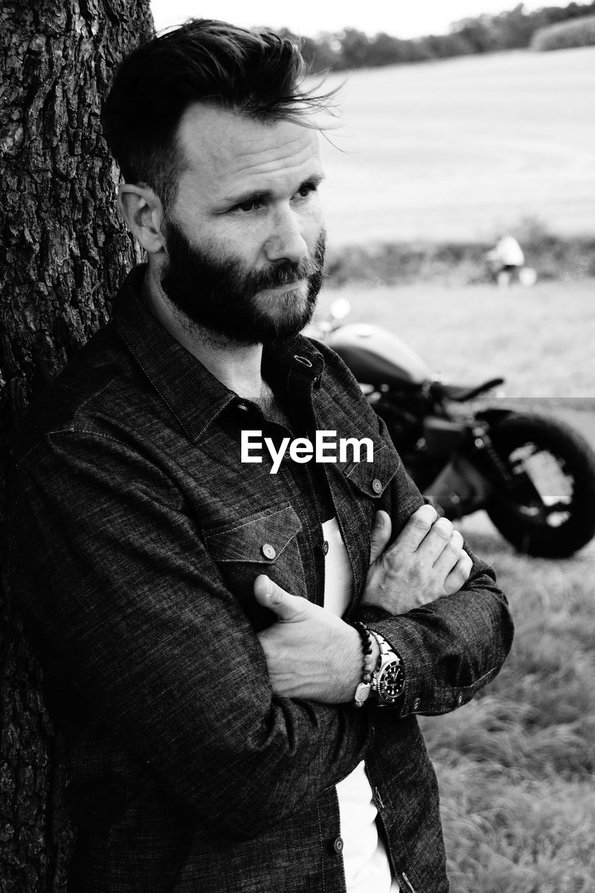 Close-up of thoughtful mature man against tree