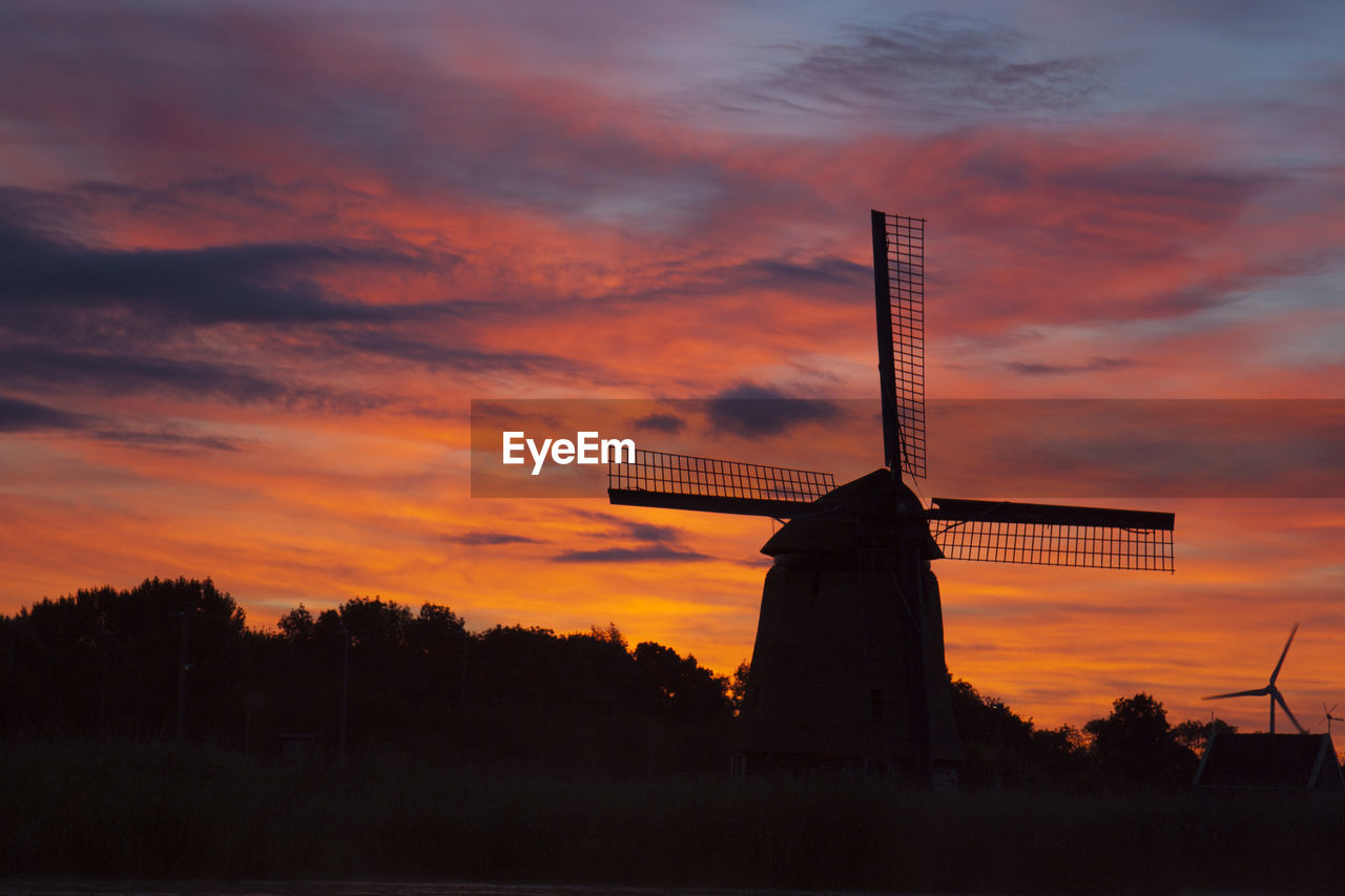 Low angle view of dutch windmill against sky during sunset