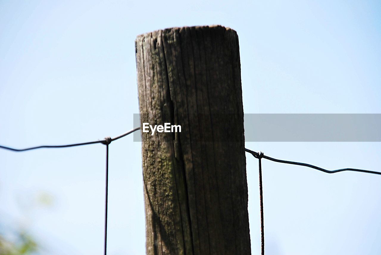 Low angle view of wooden post against sky