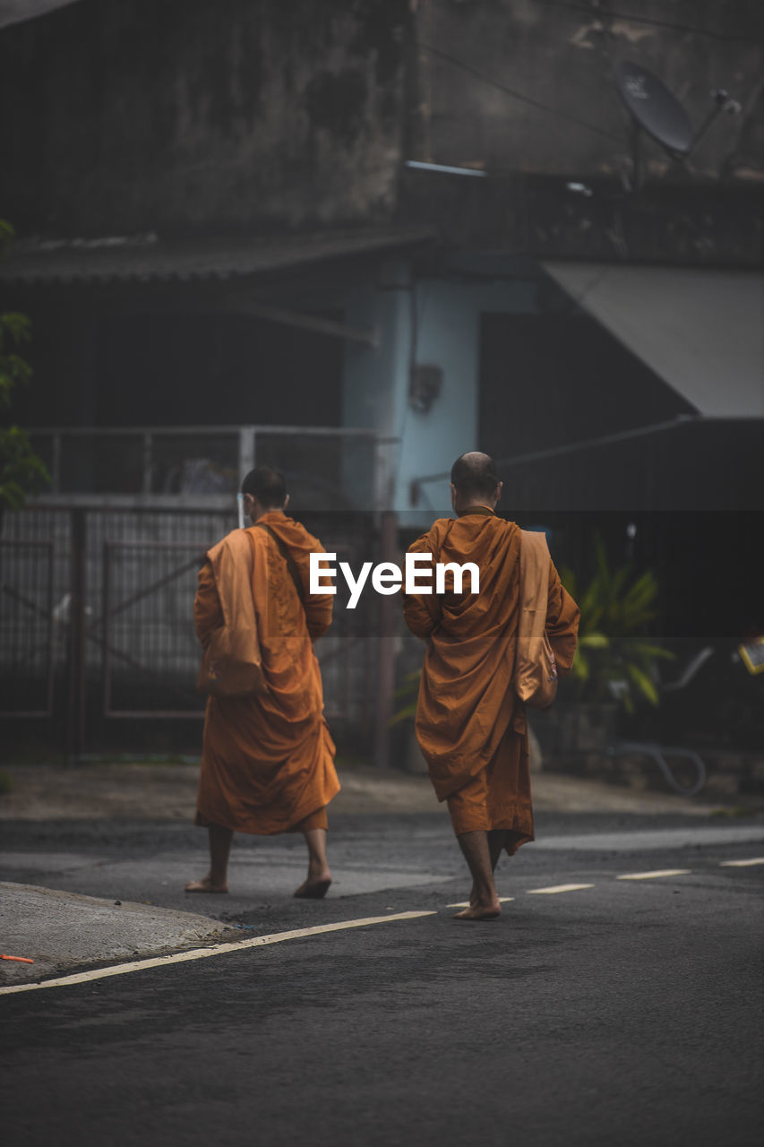 Rear view of people walking on road